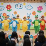 어린이 동시 발표회에서 귀여운 의상을 입고 율동을 하는 유치원생들