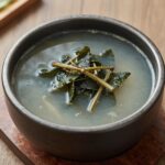 바지락냉이국 만드는 법과 맛있게 끓이는 비결 푸른 냉이와 신선한 바지락이 담긴 보울에 담긴 맑은 바지락냉이국