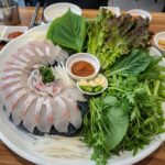 도다리회와 다양한 쌈 채소가 접시에 담겨 있는 모습