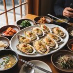 접시에 담긴 커다란 하동 벚굴 구이와 다양한 반찬들