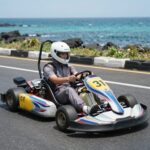 4월 제주도 봄 여행 완벽 플랜 제주 981파크에서 레이싱 카트를 타고 있는 모습, 바다 배경이 보인다
