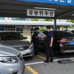 공공기관 주차장 입구에서 직원이 차량 번호판을 확인하는 모습