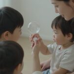 아이와 안전하게 버블건 사용하는 모습, 엄마가 아이 손을 잡고 버튼을 누르고 있음