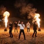 코첼라 사막 야간 무대에서 빅뱅 멤버들이 화려한 조명과 불꽃을 배경으로 퍼포먼스를 선보이는 모습