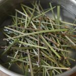 데친 머위나물을 찬물에 헹구는 모습