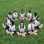 푸른 잔디밭에서 포카리 스타일 나시 반티를 입고 포즈를 취하는 학생들 단체 사진