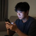 포모스 불안을 느끼는 사람이 스마트폰을 응시하는 모습