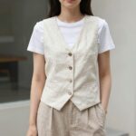 린넨베스트로 시원한 봄여름 스타일링 아이보리 린넨베스트를 화이트 티셔츠와 베이지 와이드 팬츠 위에 레이어드한 여성의 여름 스타일링 사진