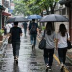 2026 장마철 기간 미리보기 2026년 장마철 도시의 빗길 풍경, 우산을 쓴 사람들