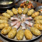 화명동장미공원 근처 맛집에서 즐길 수 있는 다양한 음식 사진으로 보쌈, 돈카츠, 생선구이, 피자 접시가 나란히 놓여 있다