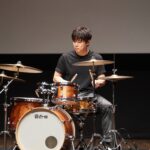 권순근 드러머 음악 세계 권순근 드러머가 무대에서 강렬하게 드럼을 연주하는 모습, 그의 전율적인 리듬을 상징
