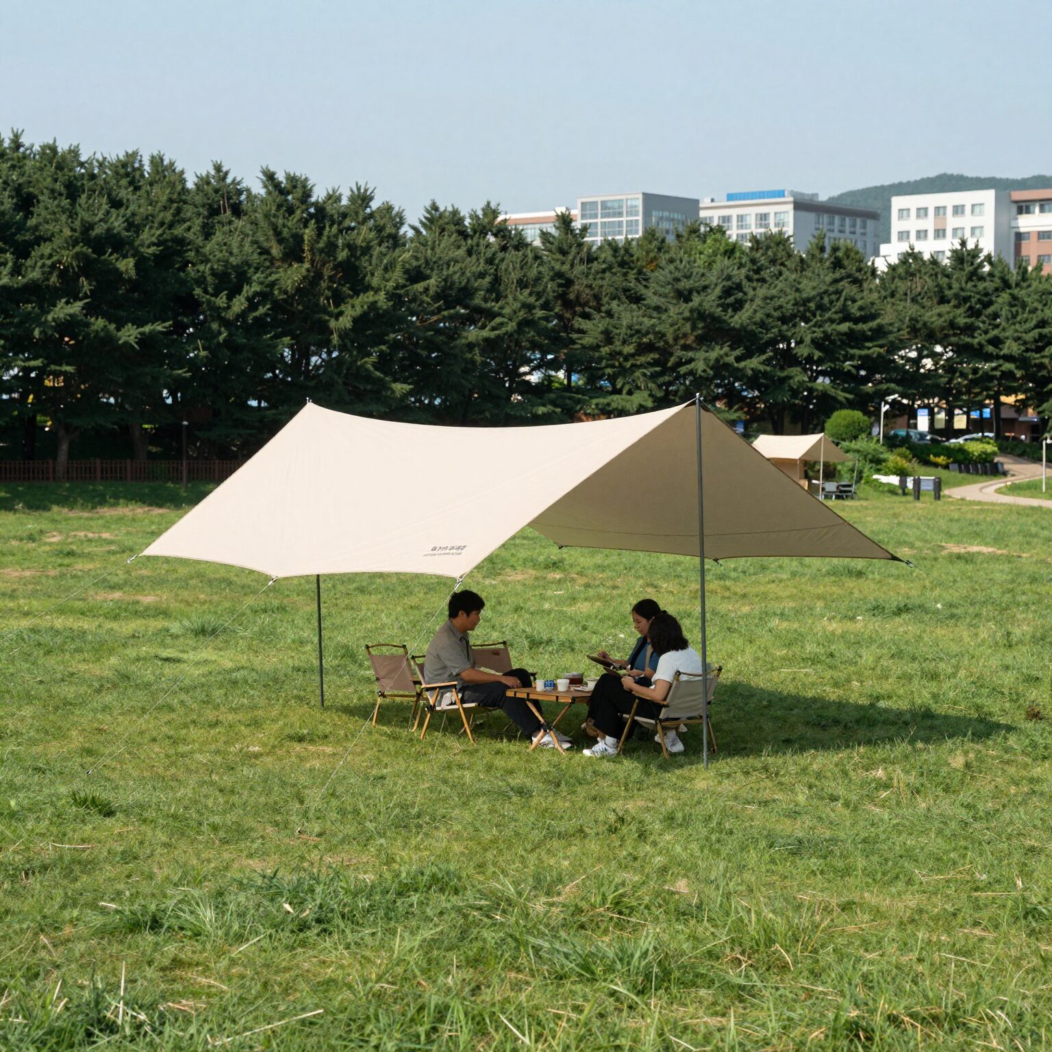 넓은 잔디밭에 설치된 캠핑 타프 그늘막 모습