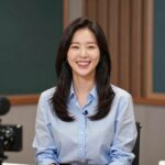 엄지인 아나운서가 KBS 스튜디오에서 진행하고 있는 모습. 화사한 블라우스를 입고 환하게 웃고 있다.