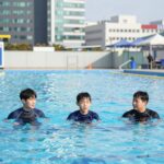 돌아기 남아가 올인원 래쉬가드를 입고 물놀이하는 모습