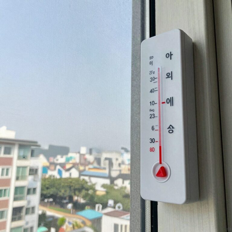 아기 방 온도계와 에어컨 리모컨, 단열필름이 설치된 창문