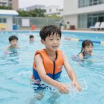 초등학생 구명조끼 브랜드 고르는 방법 초등학생이 수영장에서 구명조끼를 착용하고 물놀이하는 모습