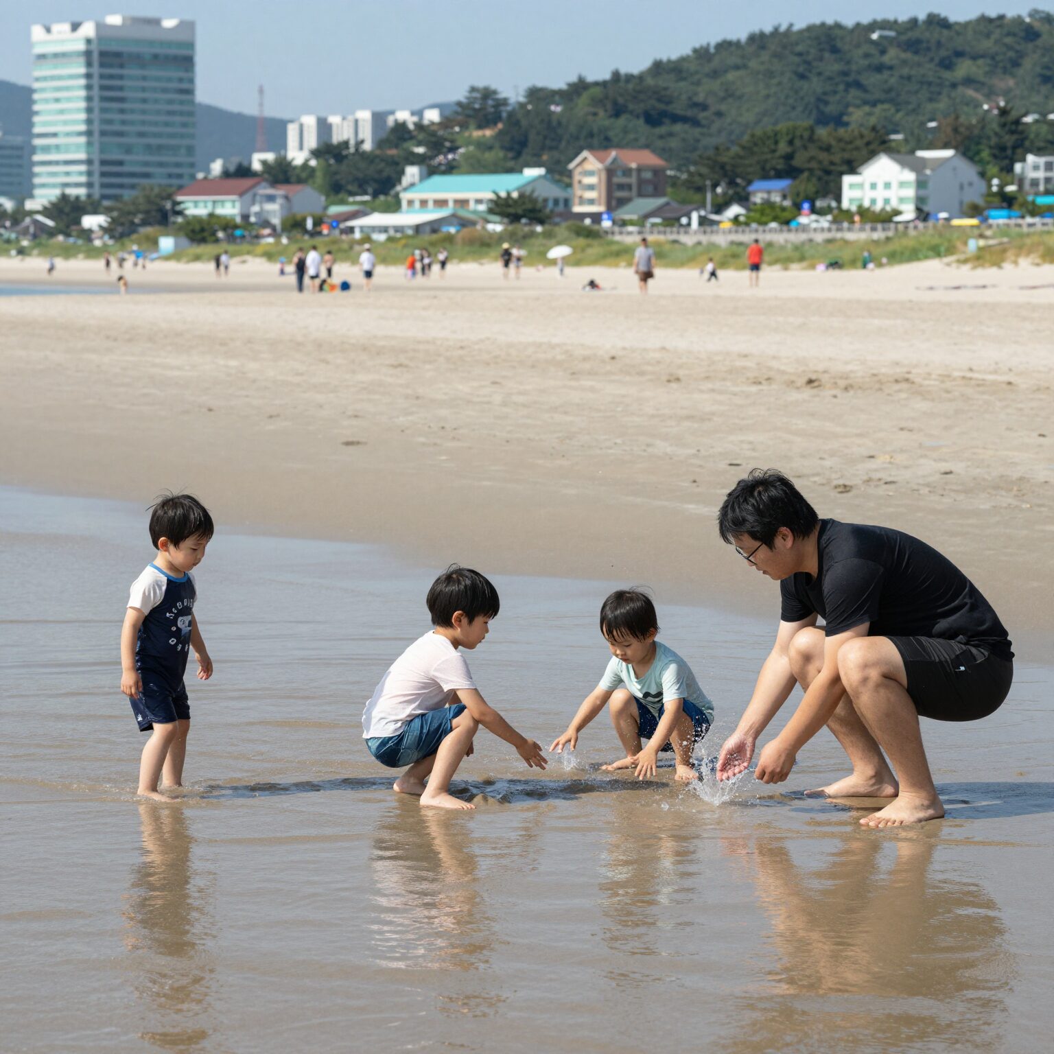 하도해수욕장에서 아이와 함께 얕은 물에서 물놀이하는 가족