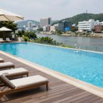 파주 수영장 펜션 중휴림 발리 감성 힐링 파주 수영장 펜션 중휴림의 야외 인피니티풀 전경, 발리 감성의 우드 데크와 선베드가 어우러진 모습