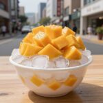 파리바게뜨 망고팥빙수가 테이블 위에 놓여 있고, 얼음 위에 망고와 팥이 올려져 있는 모습